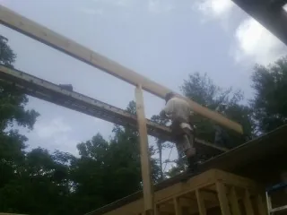 Carpenter setting a ridge beam over a new addition frame — Ice Dam Removal by Roofing Brothers in Westfir