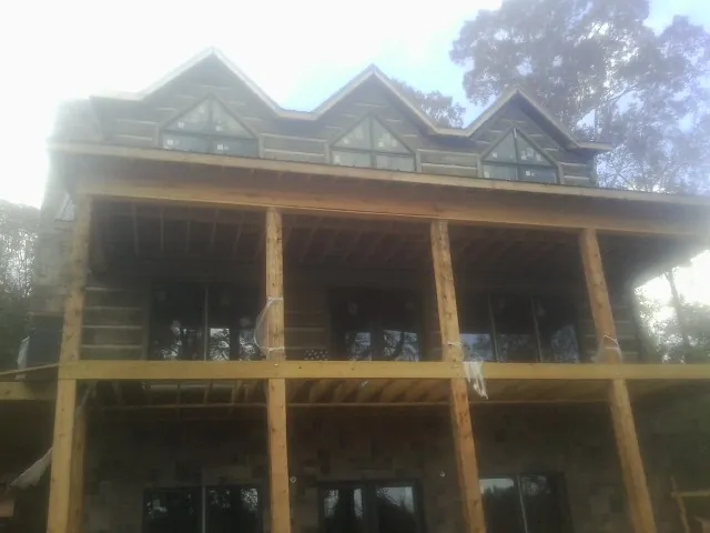 Dormers and porch framing on a large log home under construction — Roof Coating work by our crew in Westfir