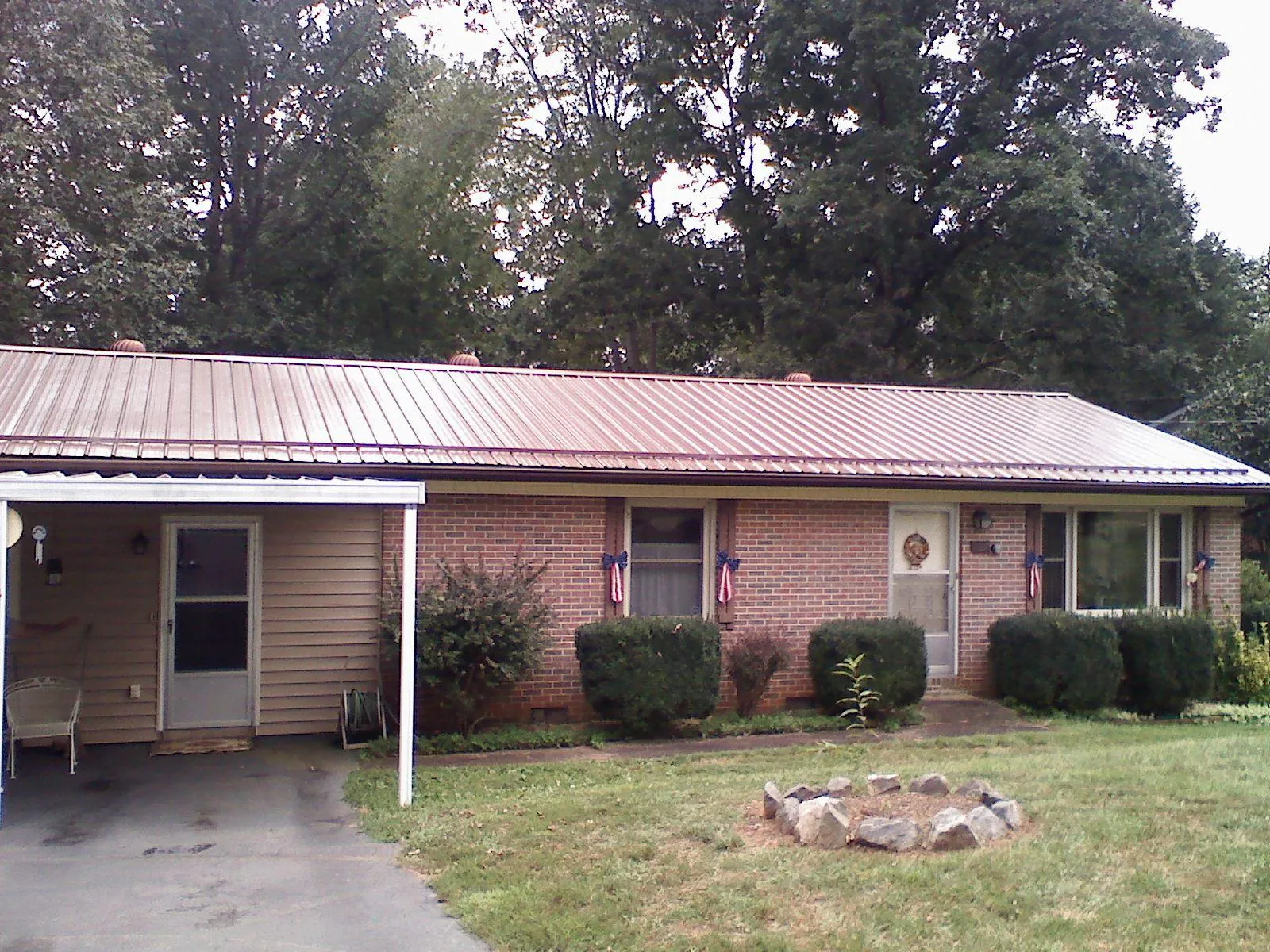 Bronze metal roof and carport on a brick ranch home — Roof Repair work by our crew in Westfir